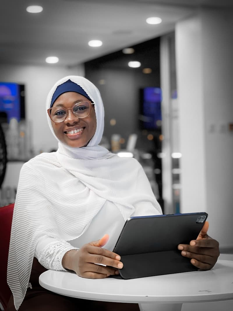 Professional woman in hijab with tablet in modern corporate office setting