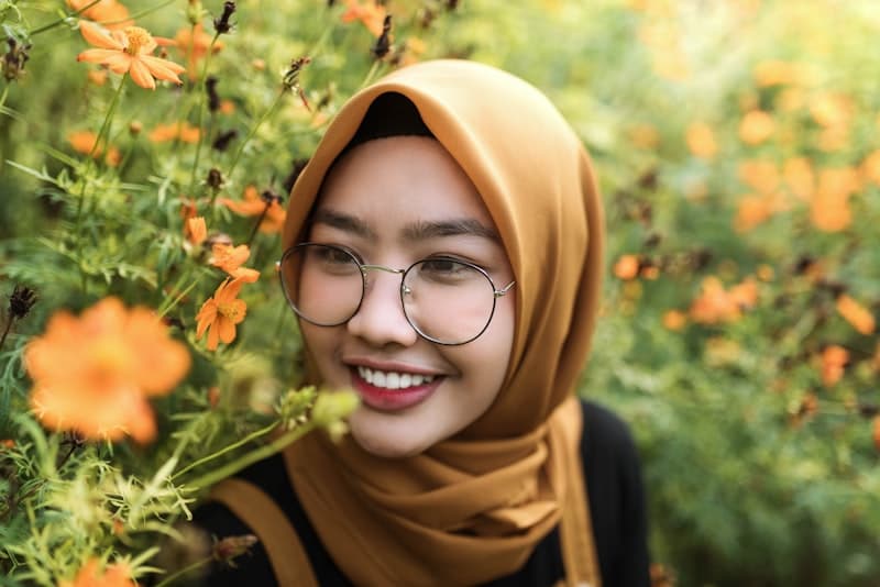 Smiling woman wearing hijab and round glasses - professional look with eyewear